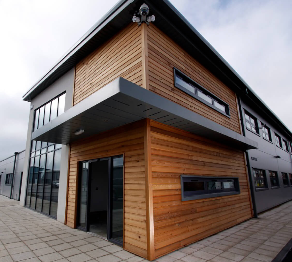 About Us: A building featuring wood siding and glass windows.