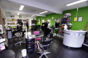 A hair salon in Grimsby with green walls and chairs.