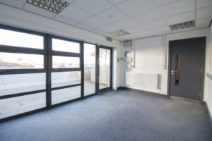 An empty office in Enterprise Village, Grimsby, with sliding glass doors.