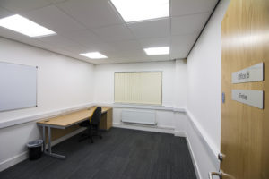 An empty office located at 9 Business Hive, 13 Dudley Street, Grimsby, with a desk and a whiteboard.
