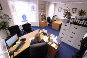 A woman is standing in front of a desk in an office located at F1, 64 St Peters Avenue, Cleethorpes.