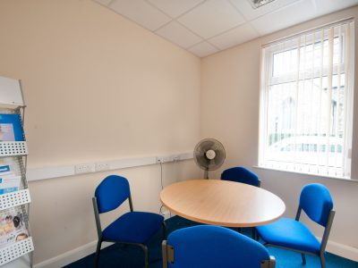 A G3 office space in Cleethorpes located at 64 St Peters Avenue, equipped with a table, chairs, and a fan.