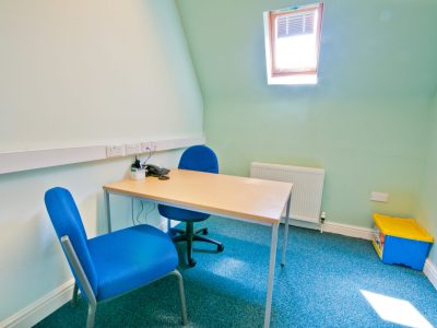 A small office with a desk and chairs.