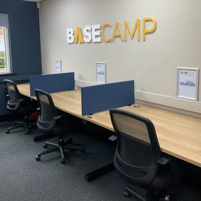 An office with desks and chairs and a sign that says BaseCamp.